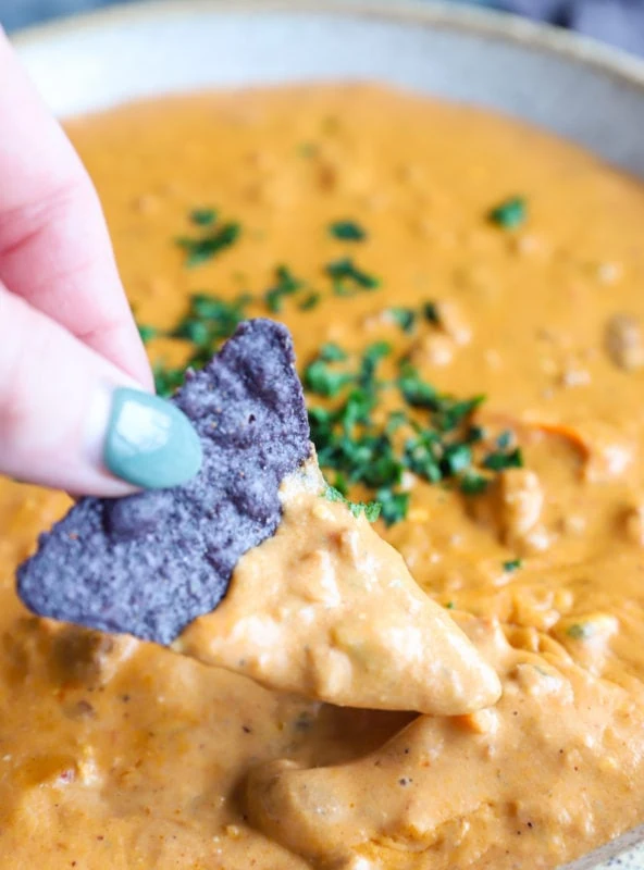 Chip dipping into queso image