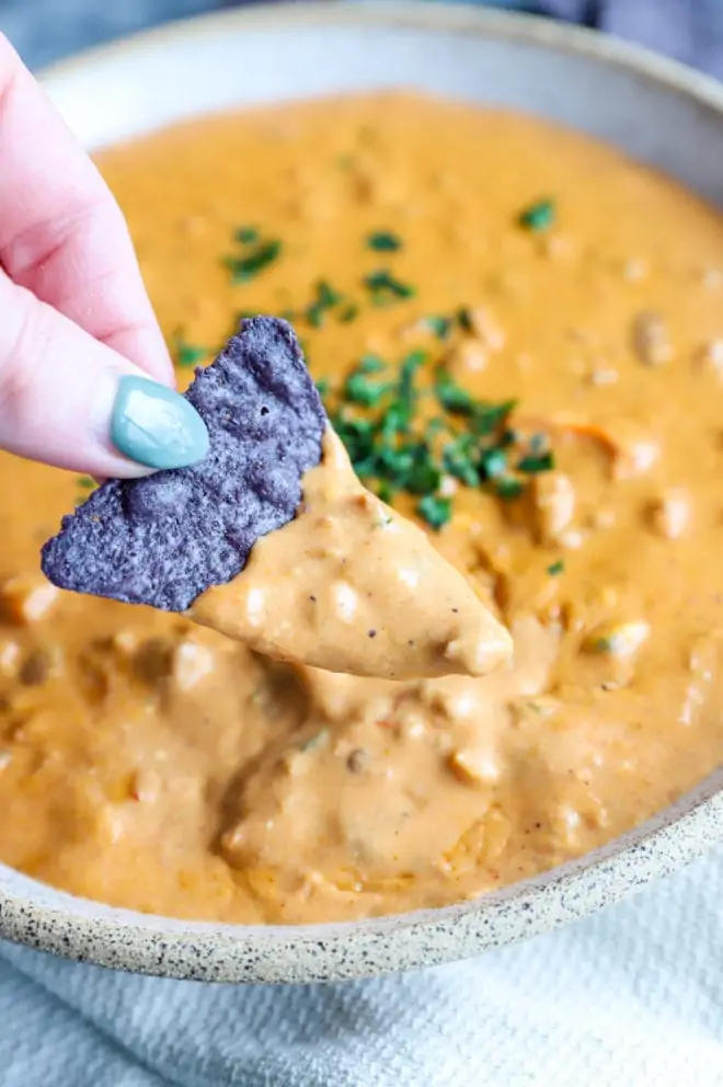 Chip dipping into chipotle chili cheese dip