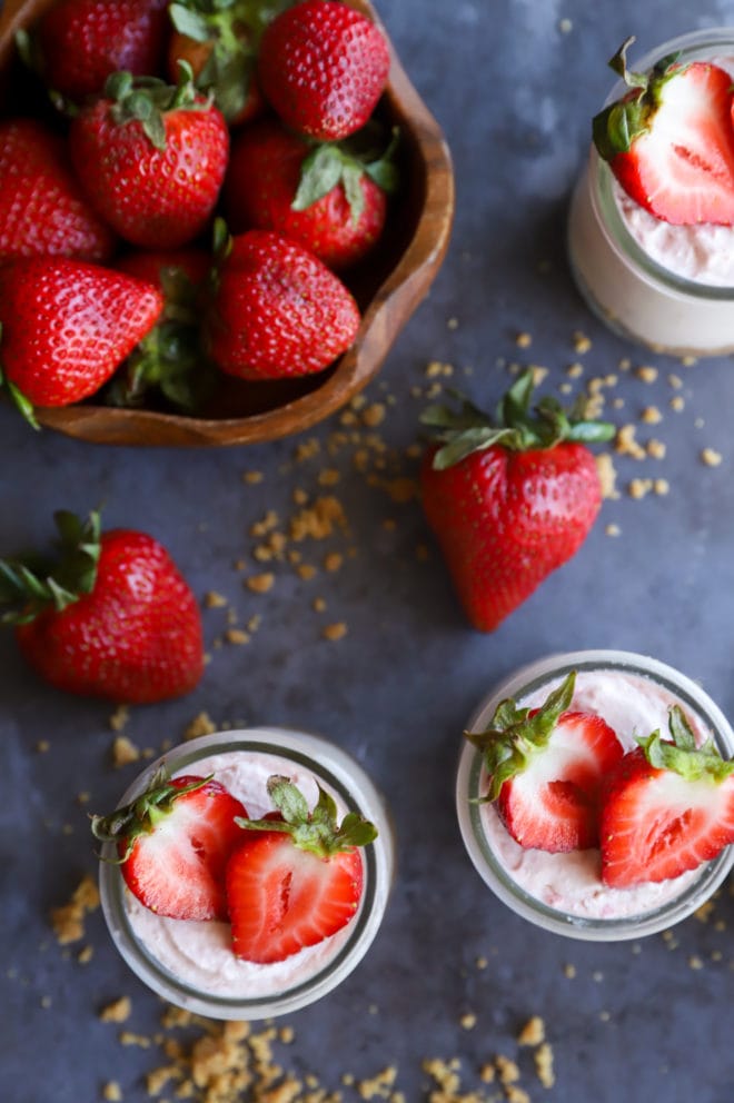 Jars with strawberry desserts and fresh strawberries