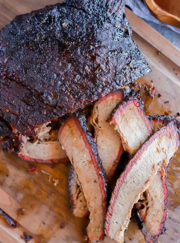 sliced smoked meat on cutting board in pile