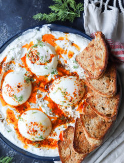 Overhead image of poached eggs platter with yogurt and butter