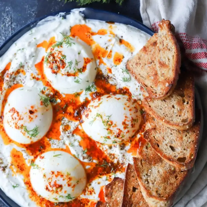 Overhead image of poached eggs platter with yogurt and butter