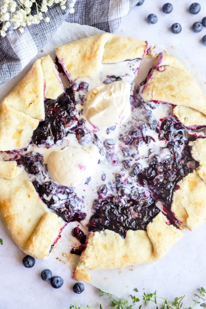 Sliced blueberry galette image overhead with ice cream