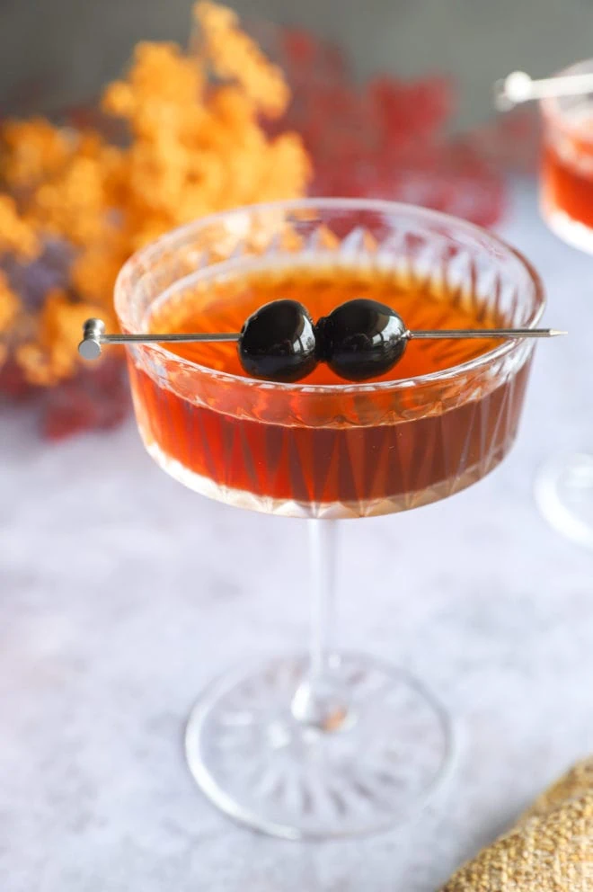 Cocktail in coupe glass with luxardo cherries
