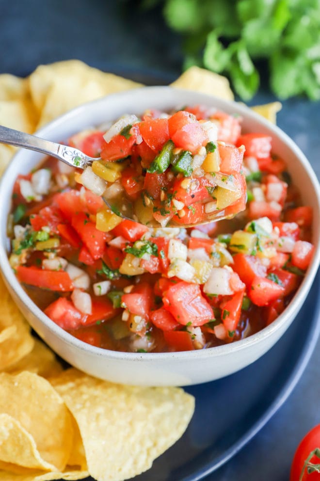 Fresh tomato salsa in bowl with spoon