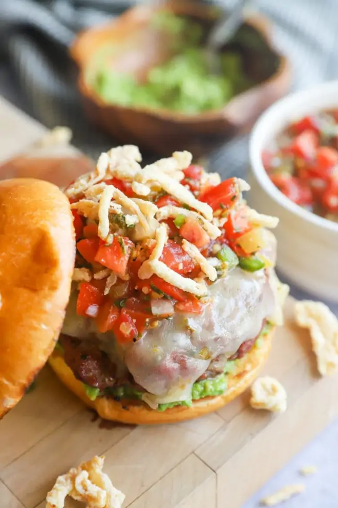 Side picture of Salsa Jalapeño Crunch Burger on a butcher's block with bowls