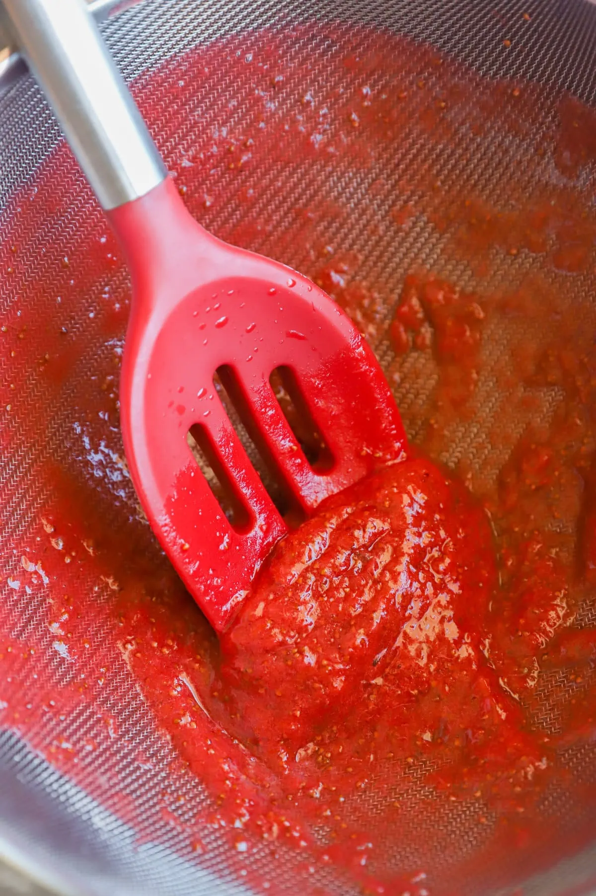 Straining coulis in strainer image