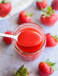Strawberry coulis on a spoon with strawberries