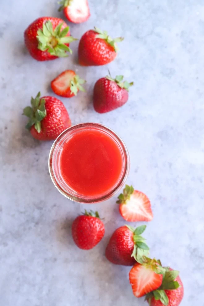 Overhead image of strawberry coulis in mason jar