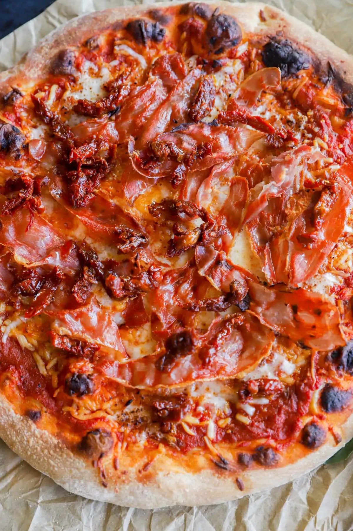 assembling pizza with sun-dried tomatoes image