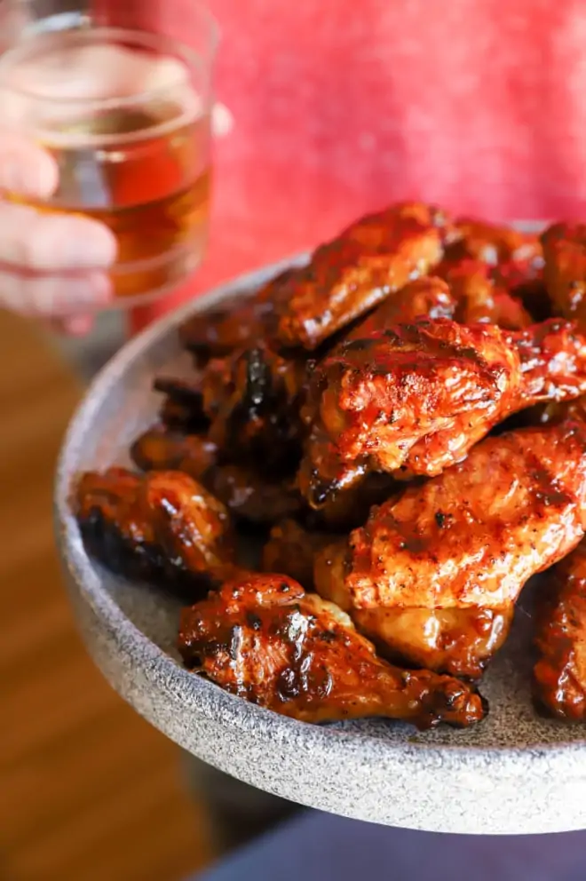Wings on a plate with whiskey in a glass