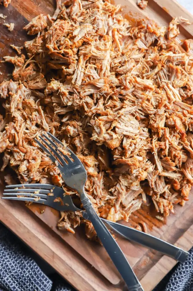 forks and cutting board with pork