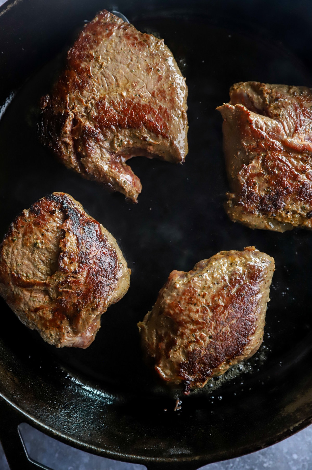 Seared sirloin steaks in cast iron skillet image