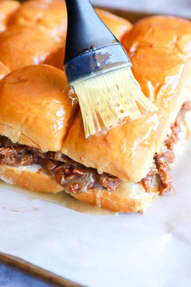 Brushing pulled pork sliders with butter image