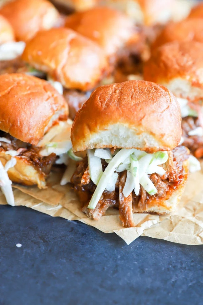 Photo of sliders on parchment paper with coleslaw