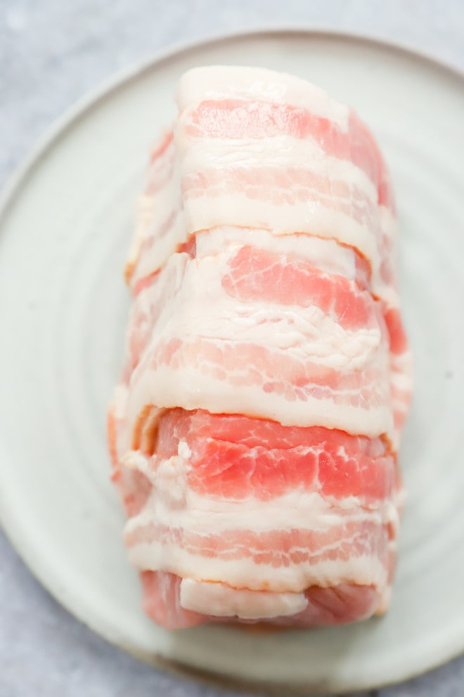 Uncooked bacon wrapped pork tenderloin image