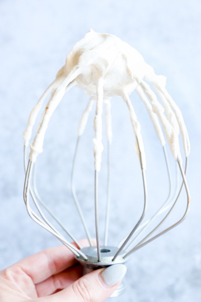 whipped cream on whisk held in hand image