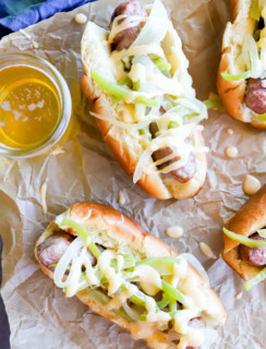 Overhead image of brats with cheese sauce