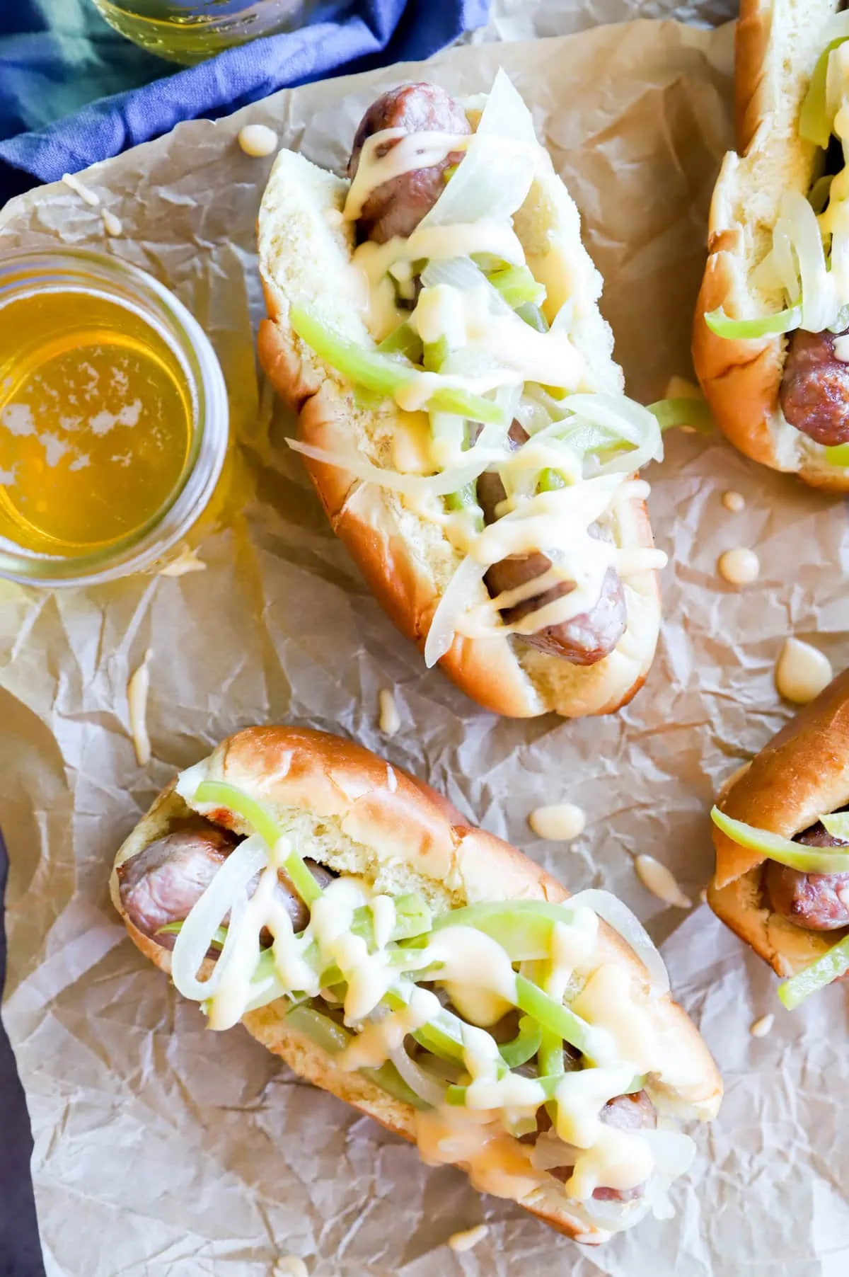 Overhead image of brats with cheese sauce