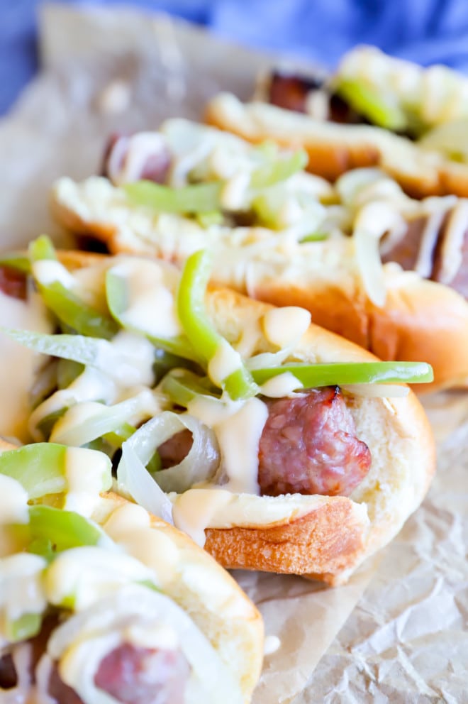 Brats in a row with cheese sauce image