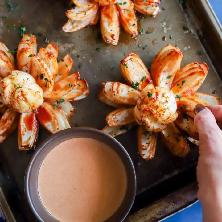 Hand taking a piece of a blooming onion