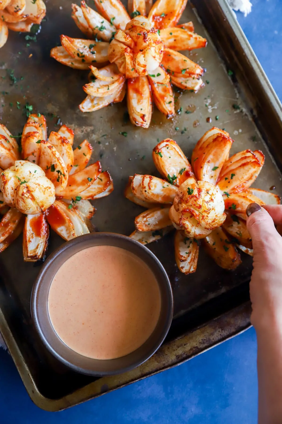 Hand taking a piece of a blooming onion