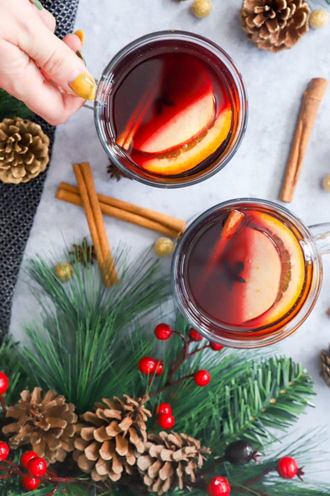 Hand holding a mug of mulled wine in clear glass