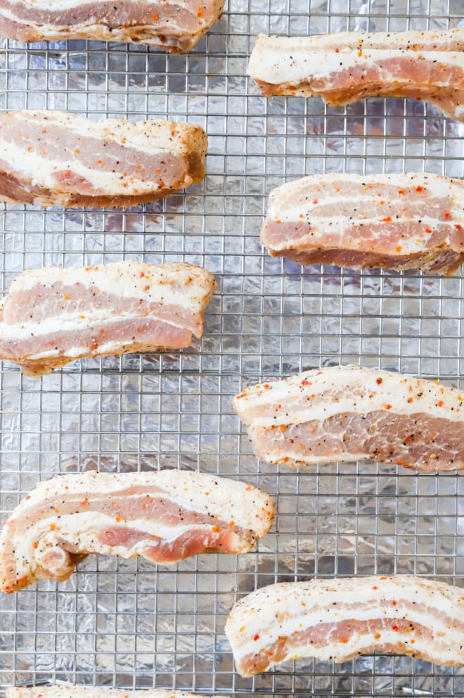 Smoky pork belly on a baking rack before baking