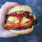Hand holding pork belly sandwich image