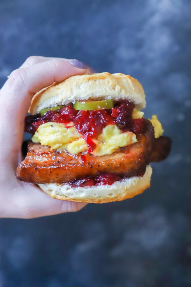 Hand holding breakfast biscuit sandwich