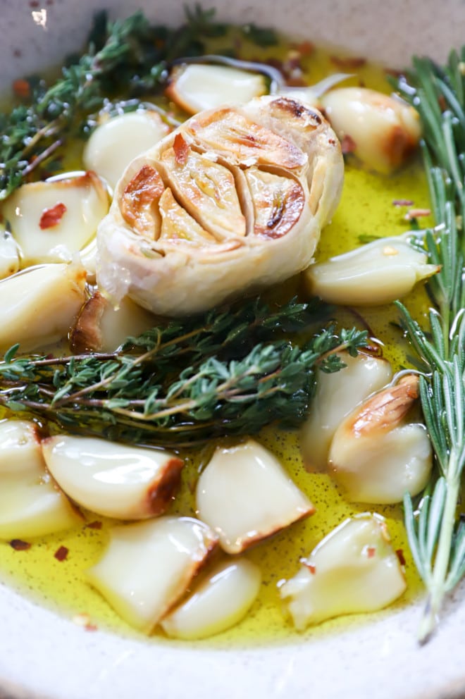 Air fryer roasted garlic in a bowl with oil