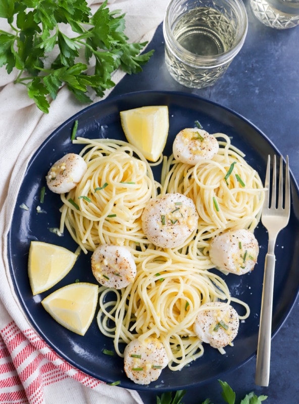 Overhead image of scallops on a plate with pasta