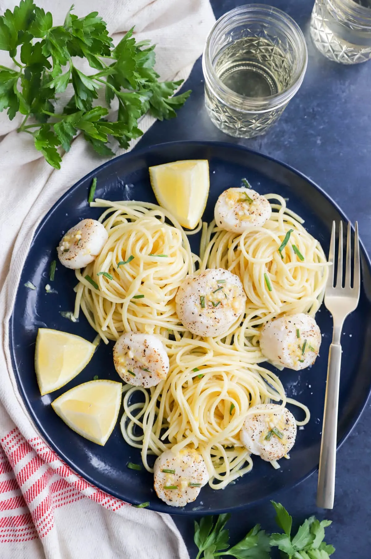 Overhead image of scallops on a plate with pasta