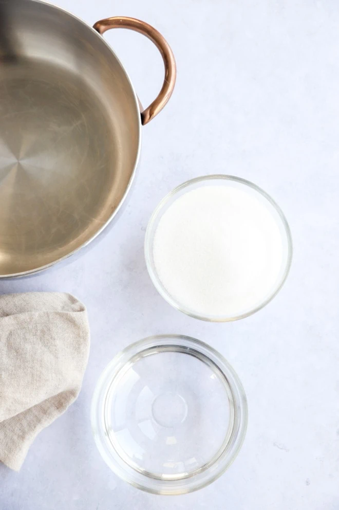 Photo of saucepan, sugar in a bowl, and water in a bowl