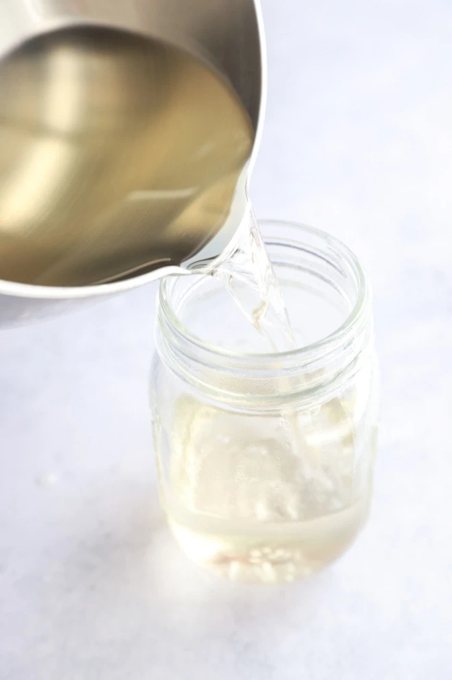 Pouring syrup into a jar from a saucepan image