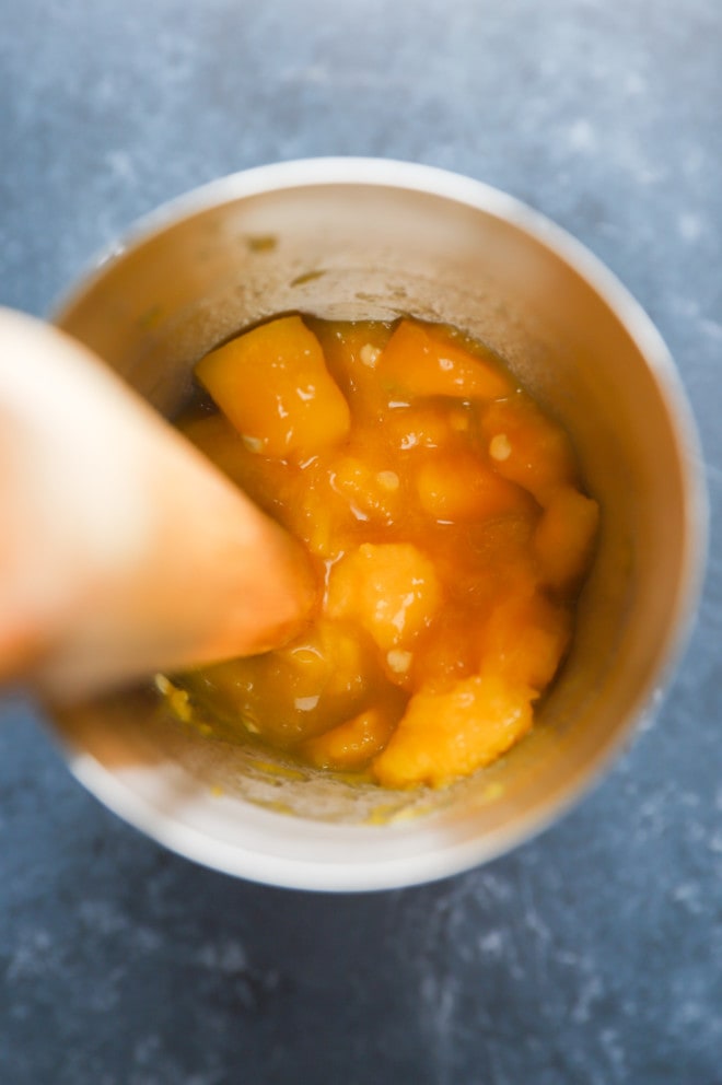 Mango muddled in cocktail shaker with jalapeno