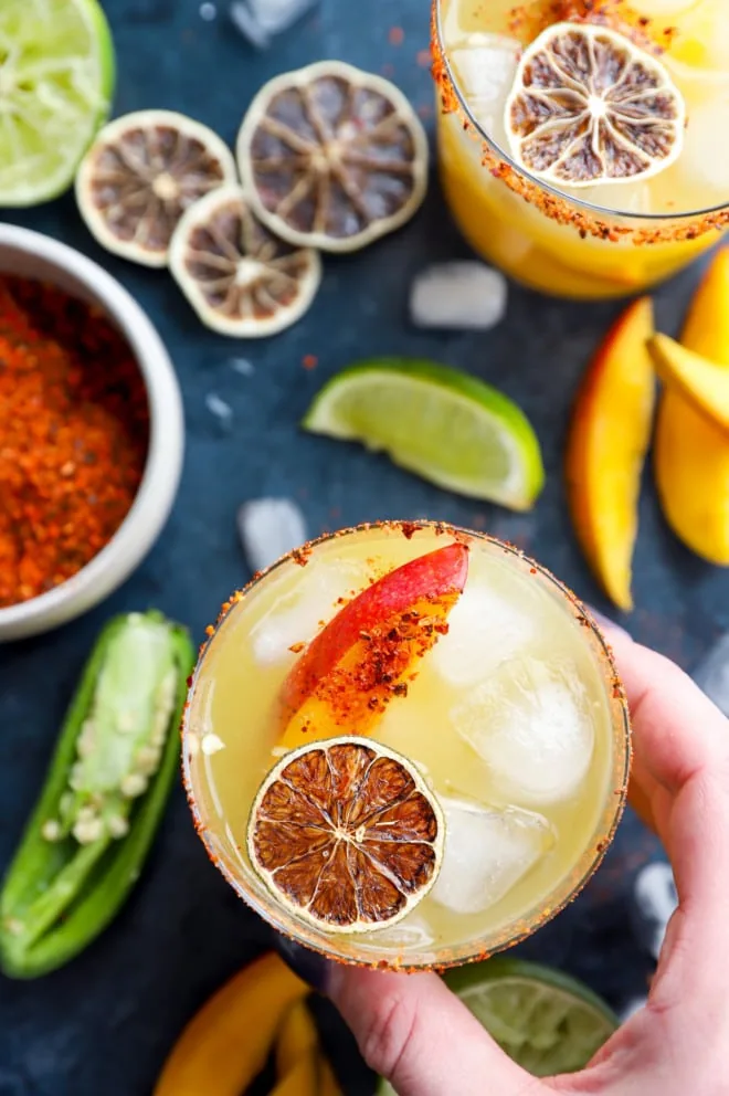 Hand holding a spicy mango margarita