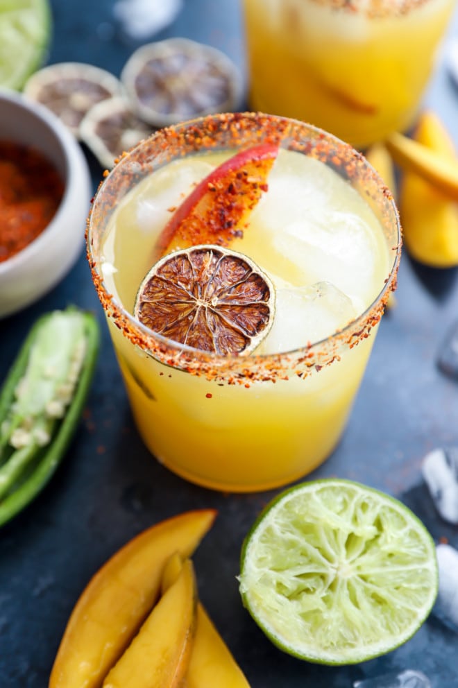 Cocktail in a glass with mango and lime garnish