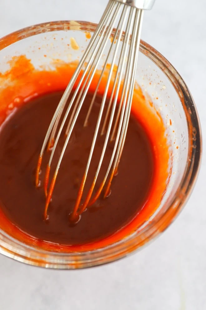 Gochujang korean sauce in a bowl with a whisk