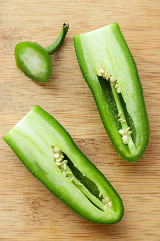 Pepper cut in half on a cutting board image