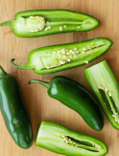 Overhead image of jalapeno peppers on cutting board