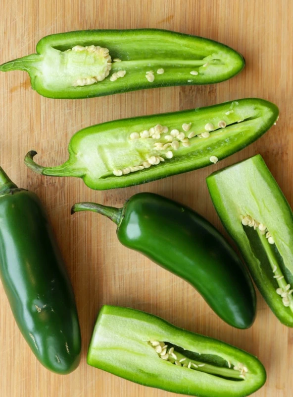 Overhead image of jalapeno peppers on cutting board