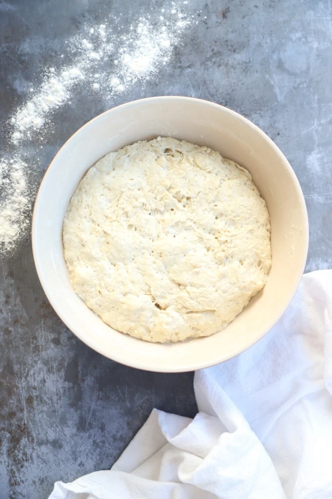 Dough rising in a bowl with flour and linen