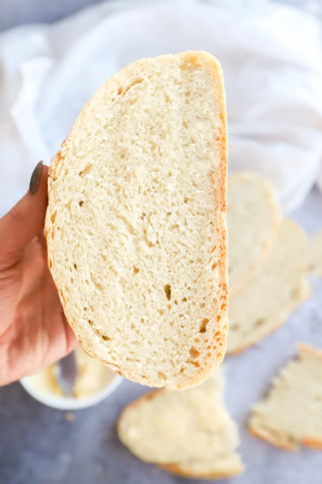Hand holding a loaf sliced in half