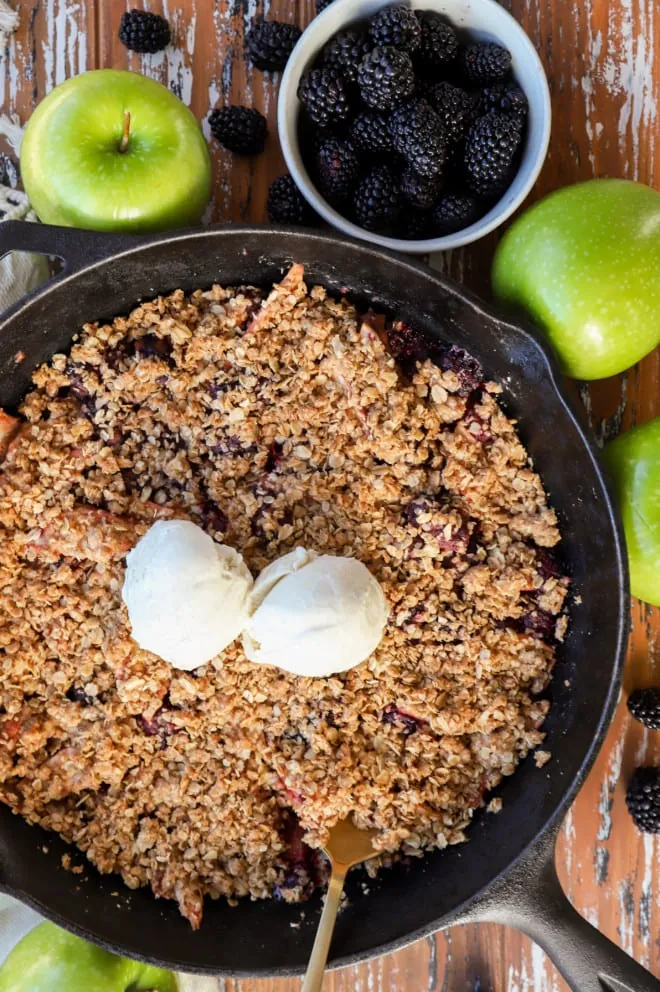 Overhead image of apple blackberry crumble with ice cream in skillet