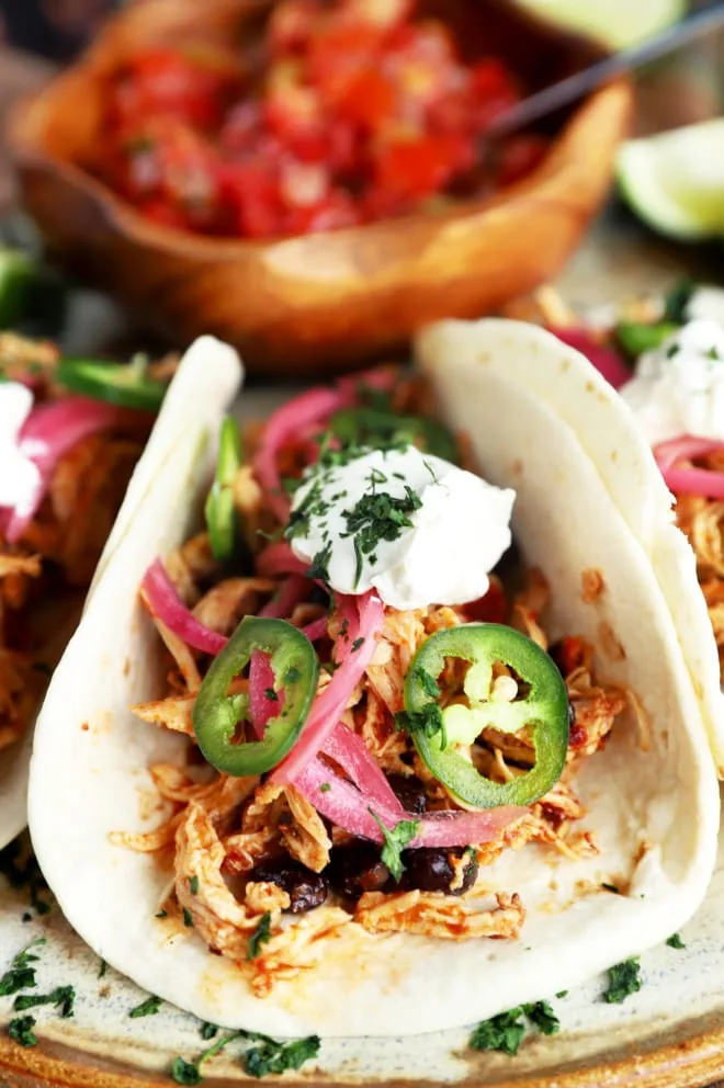 Chicken tacos with seasoning and toppings on platter