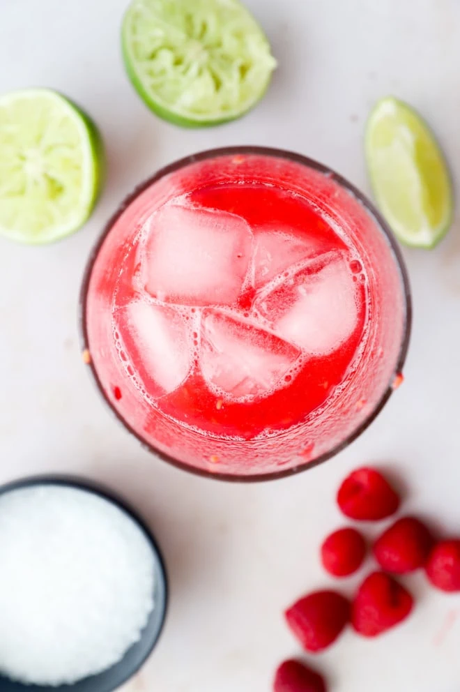 Overhead image of raspberry margarita being made in cocktail shaker