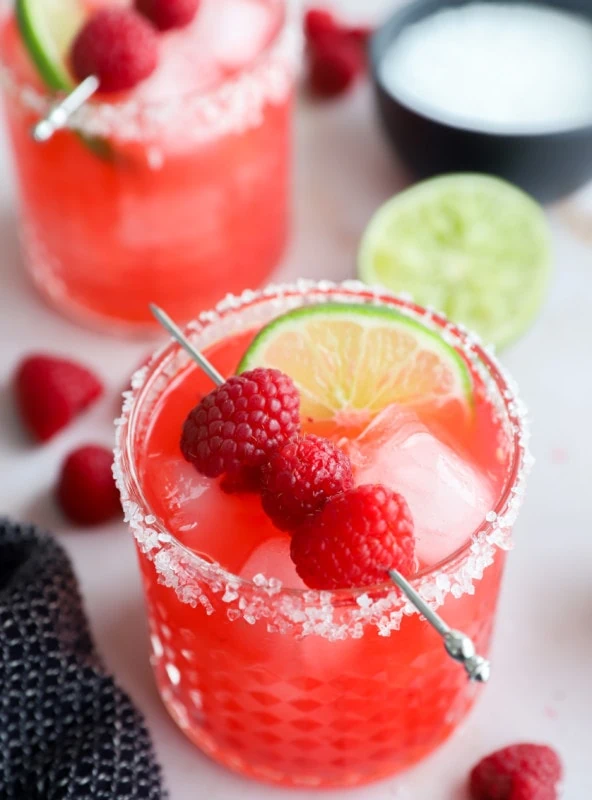 Glasses with red cocktail made out of berries and limes