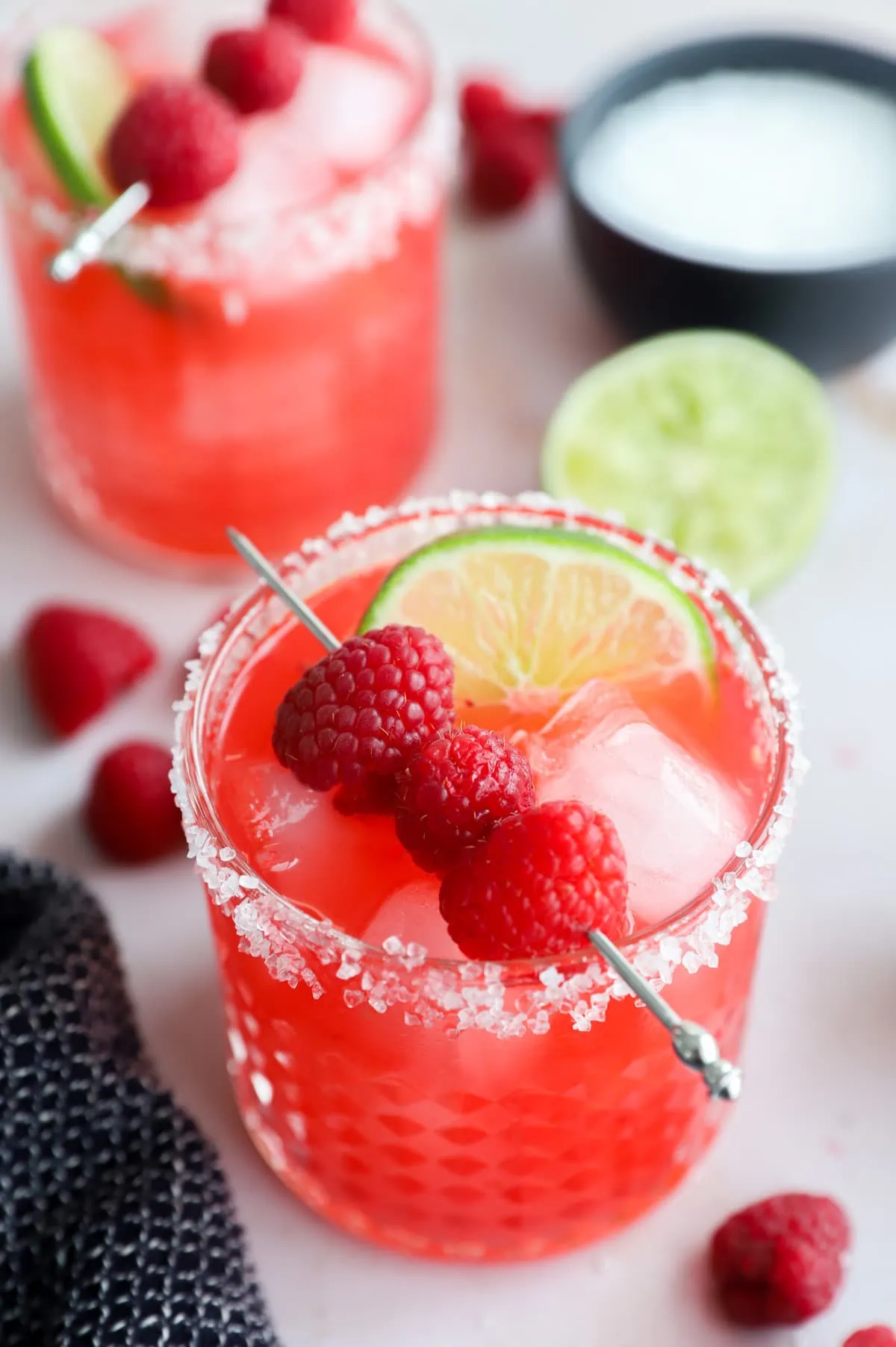 Glasses with red cocktail made out of berries and limes