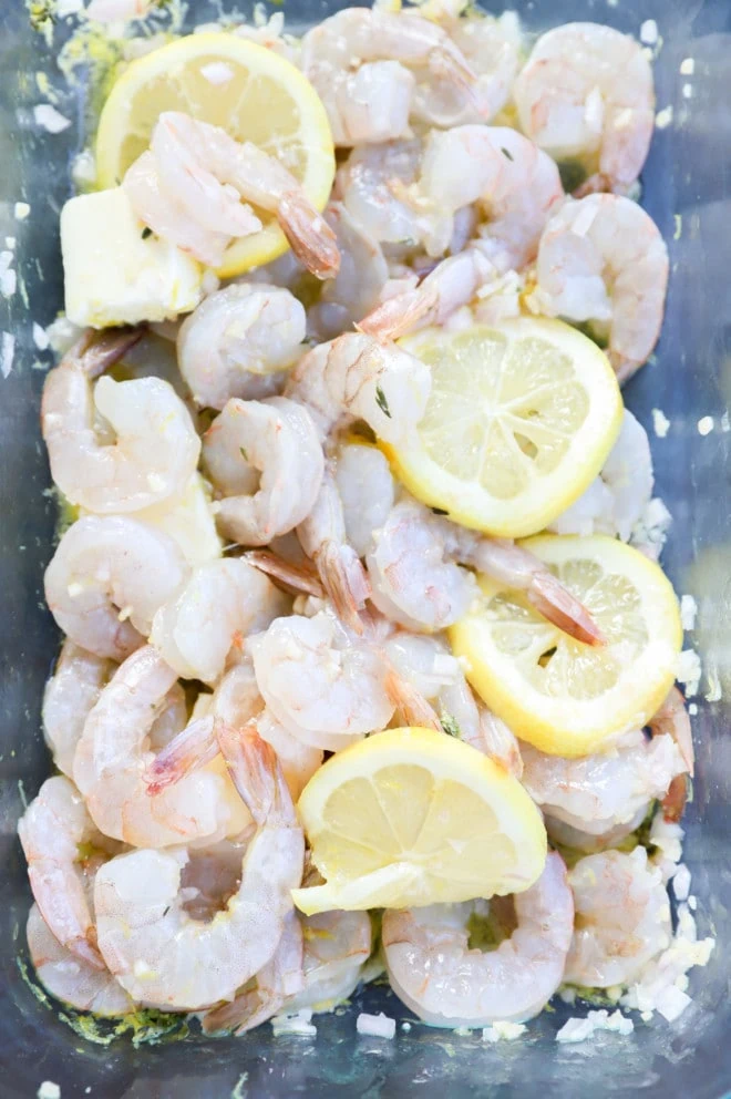 shrimp in baking dish with lemon slices, butter, and shallot picture